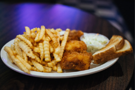Fish fry served with crinkle cut fries, coleslaw, and toast 