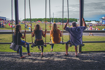 A group of 4 swinging on swings at Country Fest in Cadott, WI 