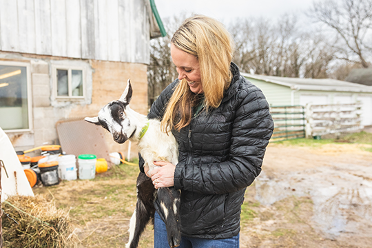 a woman holding a baby goat at a farm in Eau Claire 