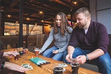 A couple playing cribbage and drinking beer at Brewing Projekt 
