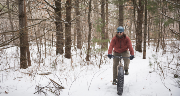 A man fat tire biking in the snow at Lowes Creek County Park 
