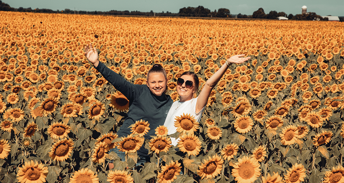 Two girls in a field of sunflowers 