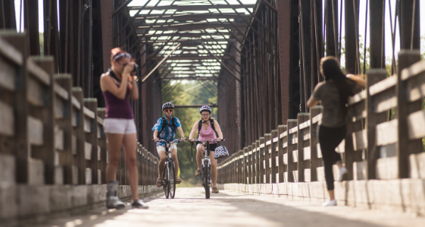 Two people riding bikes across the Phoenix Park Bridge 