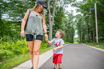 Mother and son walking on the trail together hand-in-hand at River Prairie 