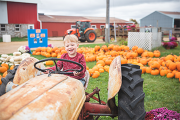 A young boy riding a tractor at Govin's Farm 