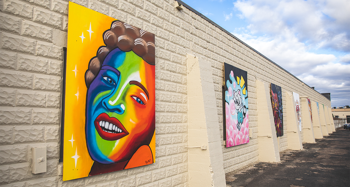 A variety of murals hanging on the Eau Claire County Shop building in Altoona, WI 