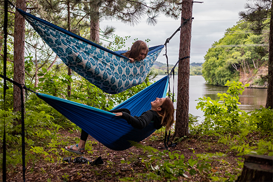 Two girls hammocking at Domer Park in Eau Claire 