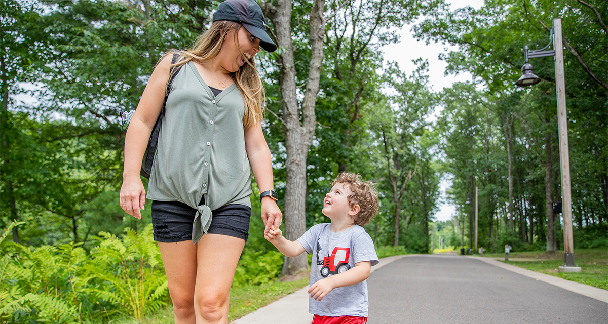 Mother and son walking on the trail together hand-in-hand at River Prairie 