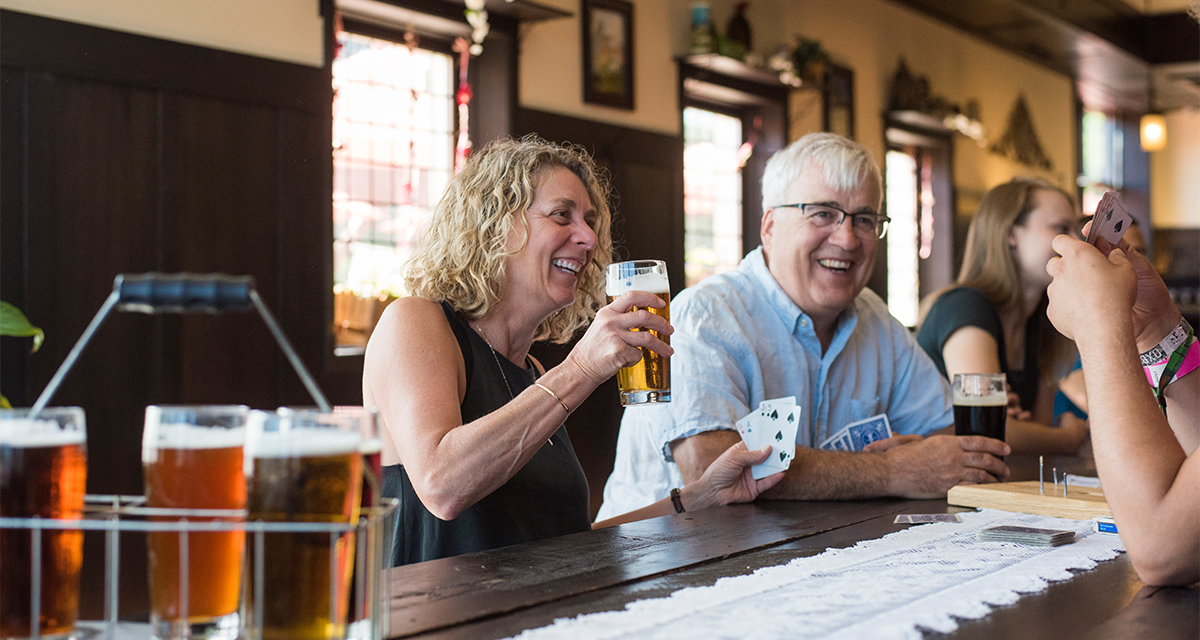 A couple enjoying beers and playing cards at Lazy Monk Brewery 