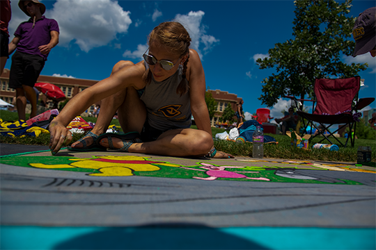 A woman drawing with chalk at Chalkfest 