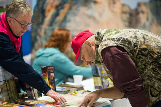A man reading brochures at the Wisconsin Sport Show 