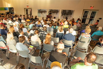 People listening to a reading at the Pablo Center 